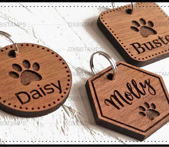 Engraved wooden pet ID tags with pet names and paw prints