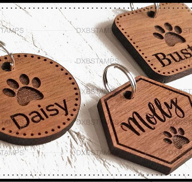 Engraved wooden pet ID tags with pet names and paw prints