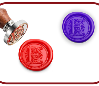 Red and purple monogram wax seals next to a brass wax stamp with a wooden handle