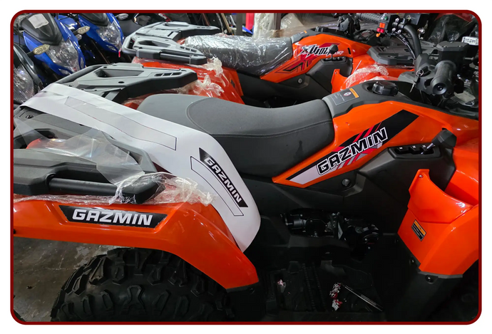 Orange and black gazmin atv with white accents on the side panels.