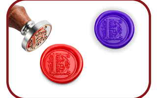Red and purple monogram wax seals next to a brass wax stamp with a wooden handle