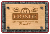 Wooden sign with 'GRANDE' branding on a stone wall background