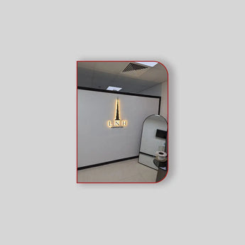 Gold and black toilet paper holder with a sleek, modern design.