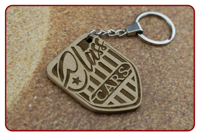 Gold ’cars’ keychain with shield design and star accents.