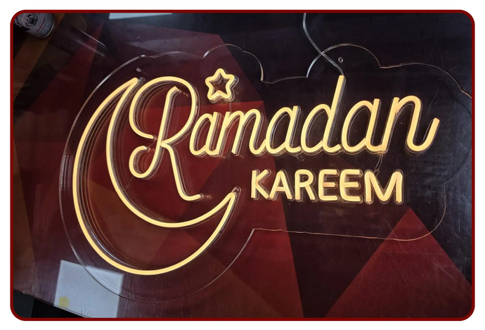 Golden neon sign displaying ’ramadan kareem’ with a crescent moon and star design.
