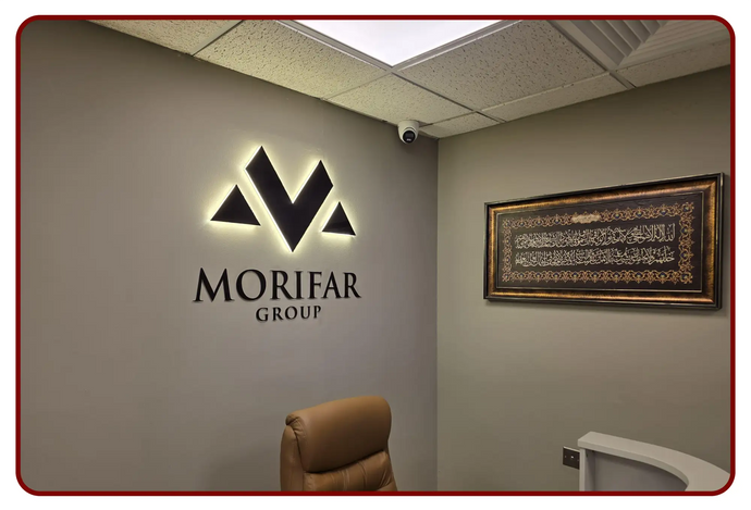 The illuminated black morifar group logo with a glowing backlight is mounted on the wall.