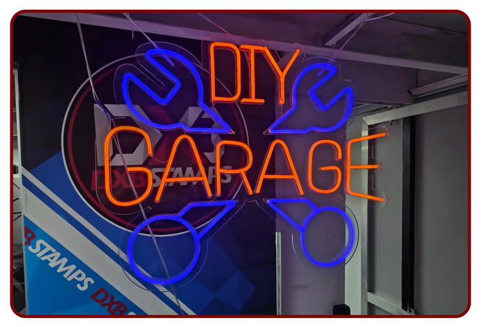 Vibrant orange and blue neon sign displaying ’diy garage’ with stylized wrench graphics.